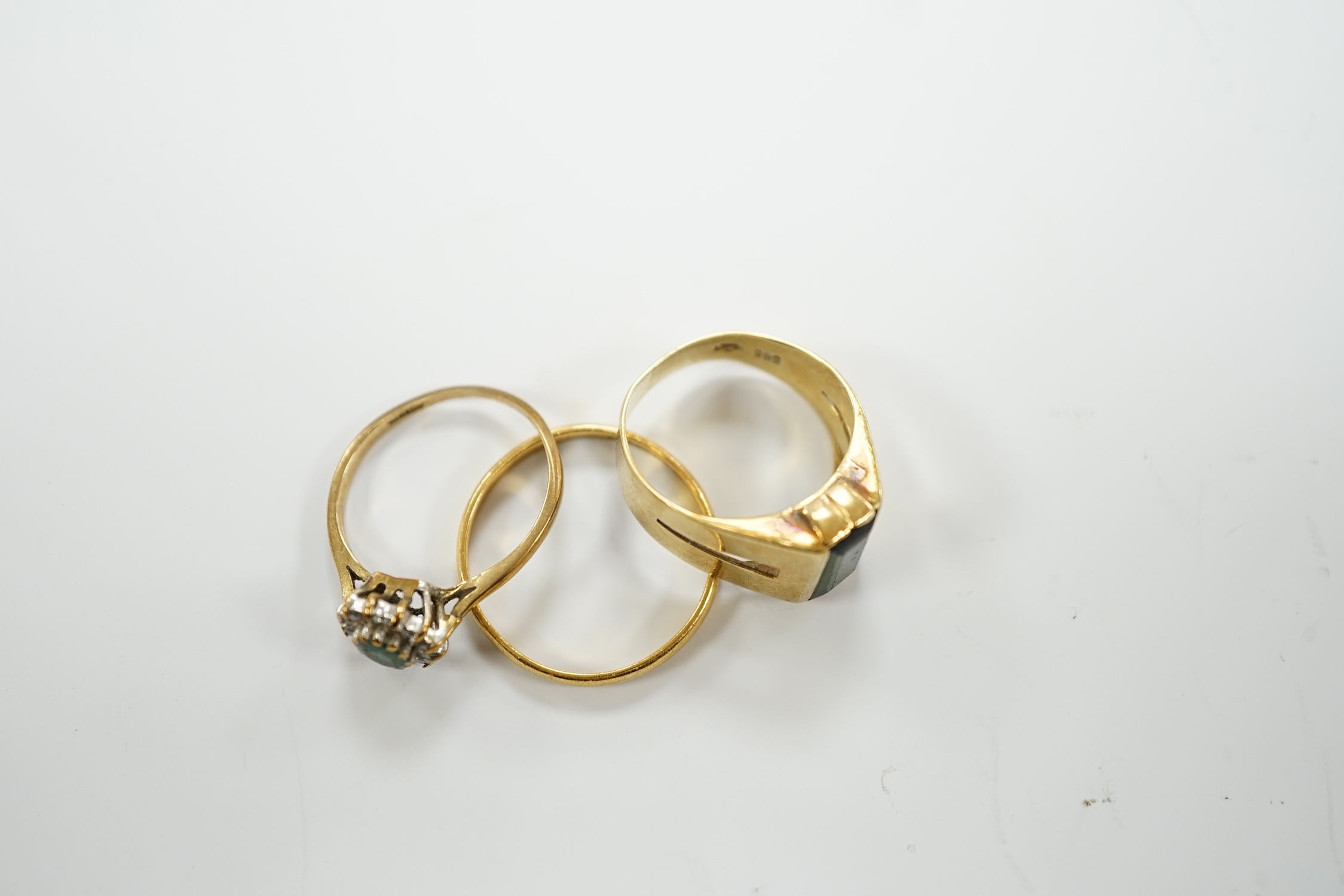 A 22ct gold wedding band, 2.2 grams, an 585 and gem set ring, gross 3.5 grams and a 9ct gold an gem set ring, gross weight 1.4 grams.